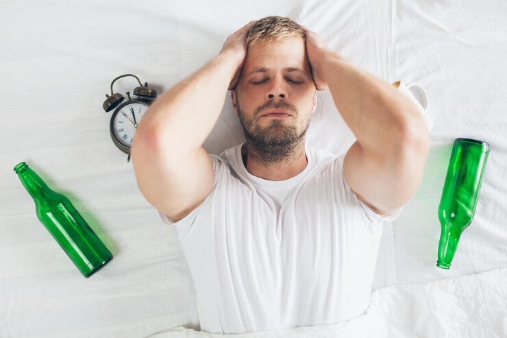 Photo young man in bed the morning after night out drinking