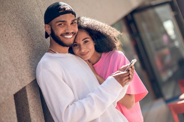 Young man in a black cap and a woman in pink tshirt in the street