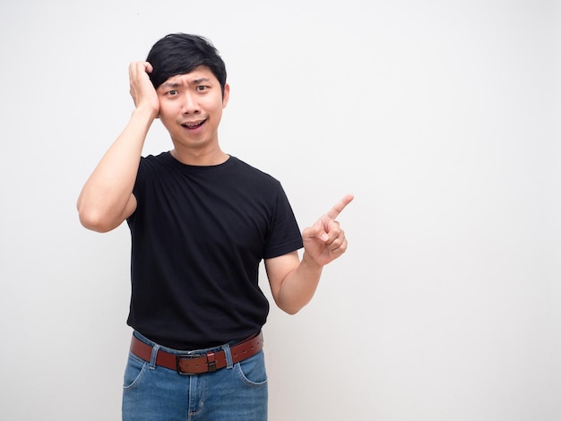 Young man black shirt confused scratch head point finger and smile