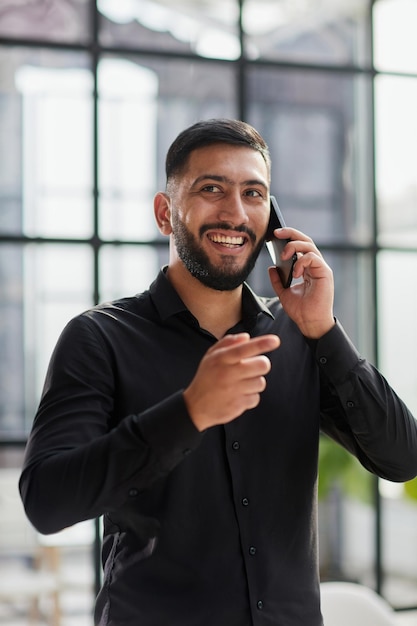 Young man in a black shirt talking on the phone