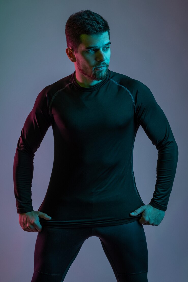 Photo young man in black sportswear confidently posing in studio