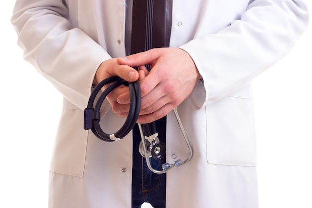 Young man in blue shirt dark tie and white doctor gown holding his stethoscope