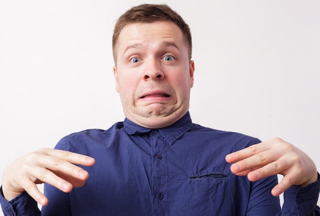 Photo young man in a blue shirt in disgust double chin wrinkles