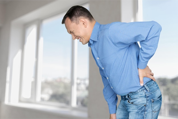 Photo young man in blue shirt feeling pain in back