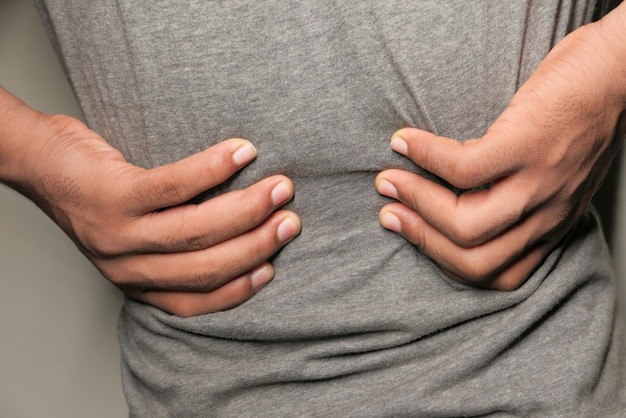 Photo young man in blue shirt suffering back pain