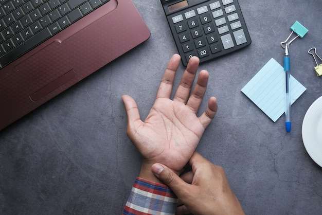 Young man in blue shirt suffering wrist pain