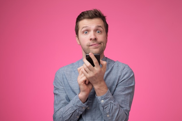 Young man in blue shirt using mobile phone