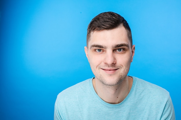 A young man in blue t-shirt smiles