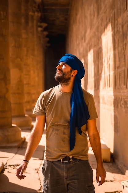 Young man in blue turban visiting the Edfu Temple near Aswan city. Egypt