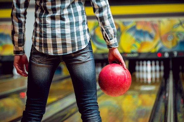 Giovane uomo al bowling con la palla.