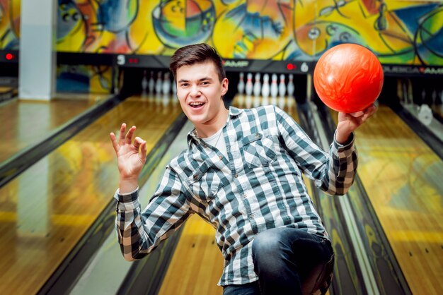 Photo young man at the bowling alley with the ball.