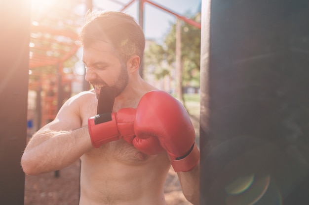 Foto allenamento di pugilato del giovane esercizio del pugile concetto di pugilato atletico pugile pugno a mano con sacco da boxe