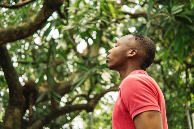 Young man breathing deep fresh air outdoor