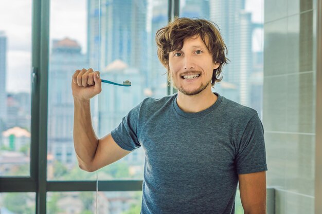 Young man brushing his teeth in his bathroom