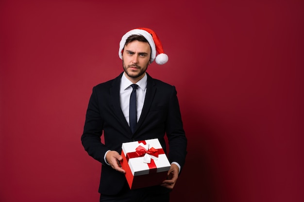 Young man in business suit and Santa hat
