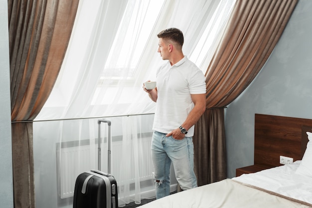 Young man business traveler hotel room accomodation