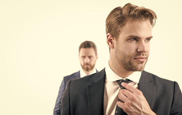 Young man businessman with serious face fix necktie in formalwear isolated on white portrait