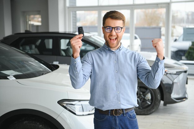 Photo young man buying first electric car in the showroom eco car sale concept