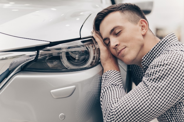 Young man buying new car at the dealership