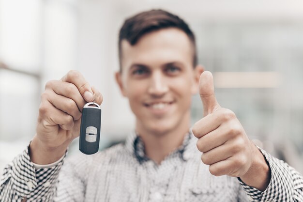 Young man buying new car at the dealership