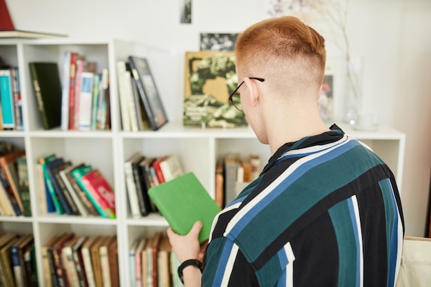 Young man buying used books in thrifting shop