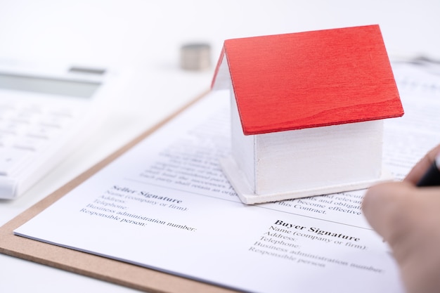 Young man calculates, signs agreement contract to buy a house