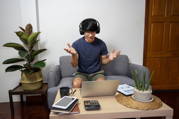 Young man calling with customer on the sofa or speak talk on video call with colleagues