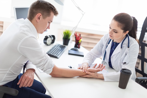 Il giovane venne a vedere il dottore. il medico misura il polso del paziente.