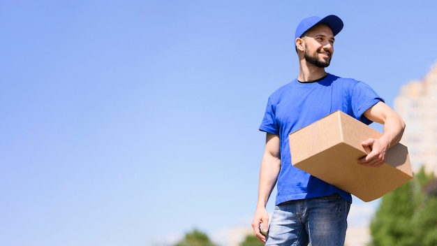 Young man carrying delivery parcel