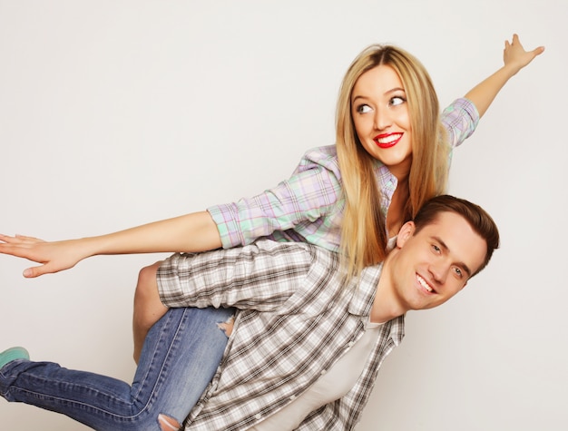 Young man carrying girlfriend on his back.