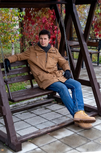公園で秋の散歩にカジュアルな服を着た若い男レジャーライフスタイル