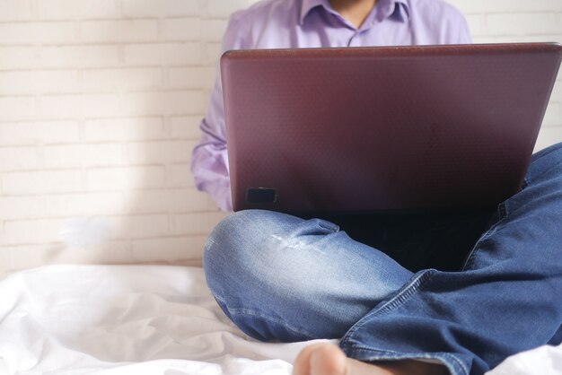 Young man in casual dress sitting on floor working from home