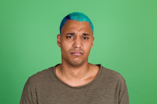 Photo young man in casual on green wall blue hair unhappy sad crying