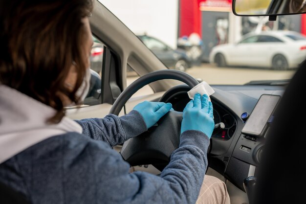 Young man in casualwear and protective gloves rubbing steer with antiseptic wipe