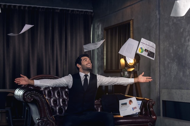 Young man celebrating in office, Businessman cheering at his desk