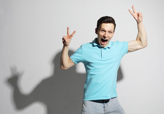 Young man celebrating victory over white background