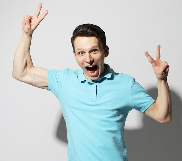 Young man celebrating victory over white background