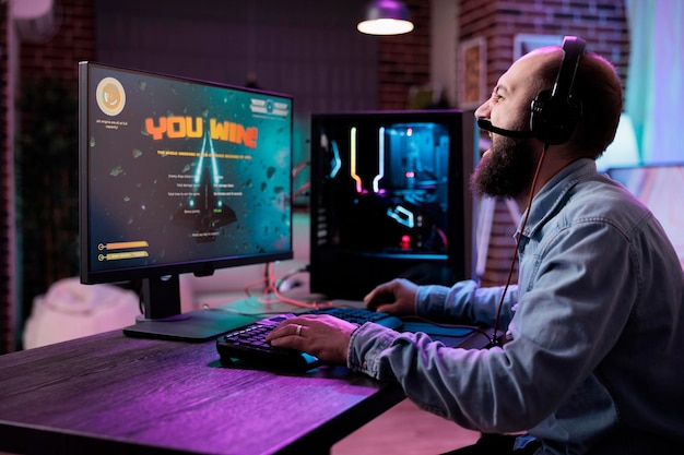 young man celebrating video games competition win on live stream, feeling happy about successful championship. cheerful male player winning action shooting tournament and enjoying gameplay.