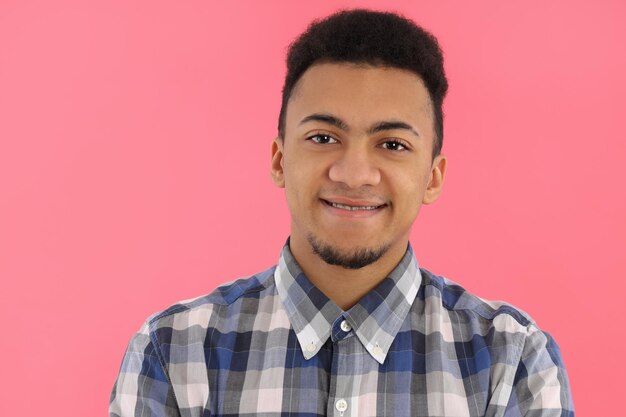 Young man in checkered shirt on pink background