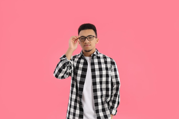 Young man in checkered shirt on pink background