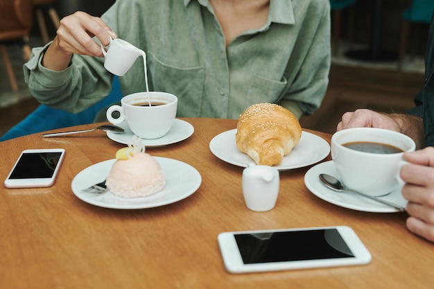 カフェでスマートフォンをチェックする若い男