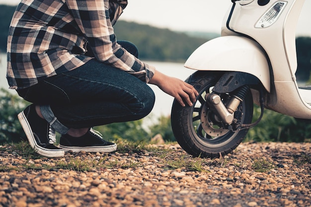 Un giovane controlla le condizioni della sua auto dopo che un'auto si è rotta durante il viaggio