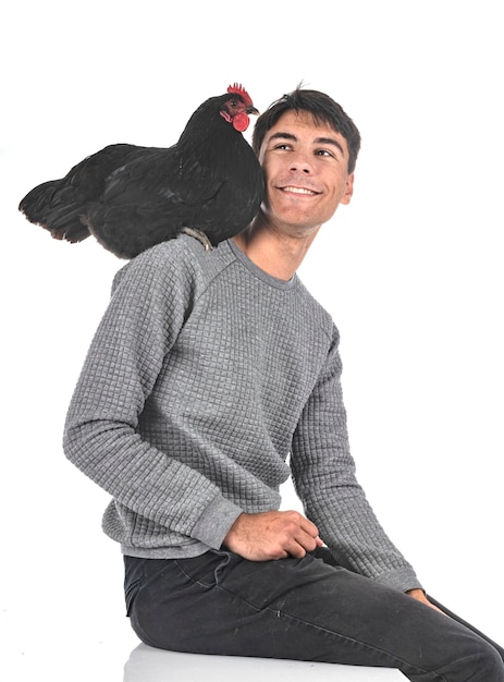 Young man and chicken in front of white background