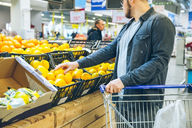 Young man choose lemon in the store