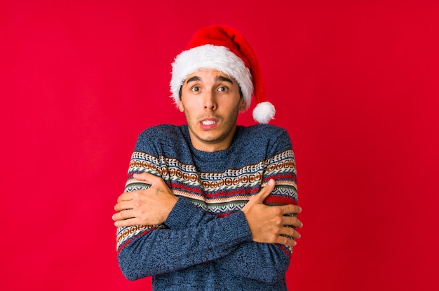 Young man on christmas day pointing upside with opened mouth.