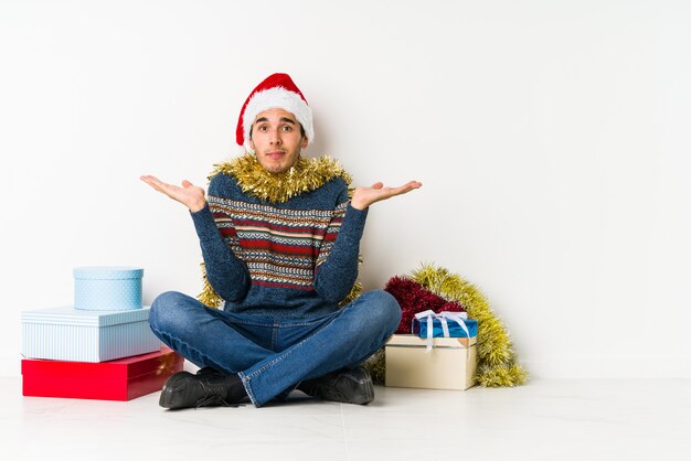 Giovane uomo il giorno di natale che grida al cielo, alzando lo sguardo, frustrato.