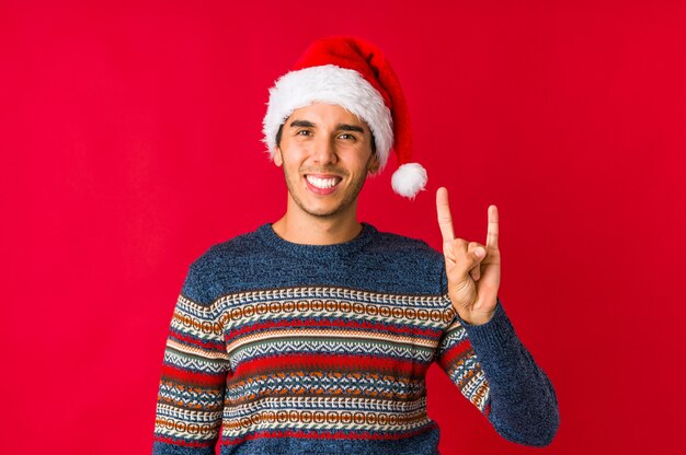 Young man on christmas day shouting and holding palm near opened mouth.