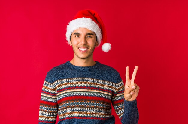 Young man on christmas day showing number one with finger.