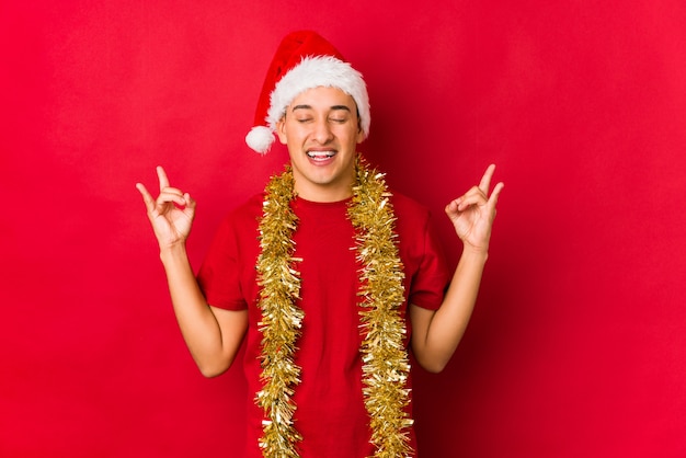 Young man on christmas day showing rock gesture with fingers