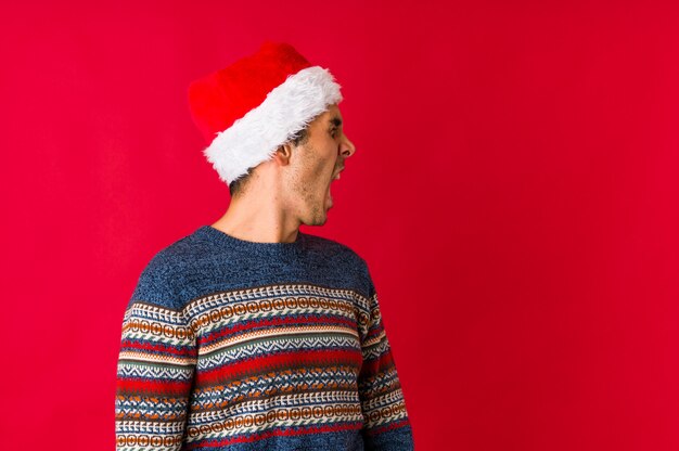 Young man on christmas day smiling confident with crossed arms.